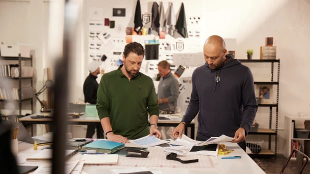 Chris Riccobono and Derek Jeter look over papers.